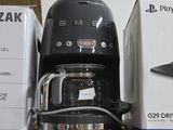 a black coffee maker sitting on top of a shelf next to a box