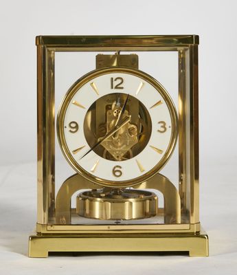 a gold clock sitting on top of a white table