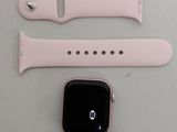 an apple watch with a pink band and a white watch face