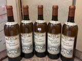 six bottles of wine are lined up on a table