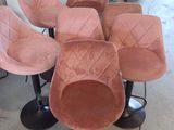 Plusieurs chaises roses sont alignées en rang dans une pièce