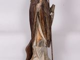statue of a man holding a staff and a staff in his hand