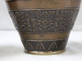 a close up of a vase on a white surface