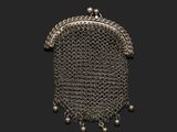 un gros plan d'un sac à main en cotte de mailles sur fond noir