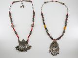 a pair of necklaces with beads and charms on them