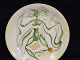 a plate with a painting on it on a black background