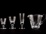 four glasses and a pitcher sitting on a table