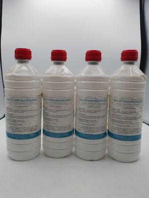 quatre bouteilles d'eau posées sur une table devant une lampe