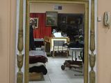 a mirror in the middle of a room with a painting on the wall