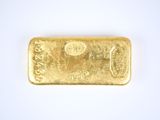 a close up of a gold bar on a white surface