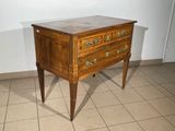 a small wooden chest of drawers on a tiled floor