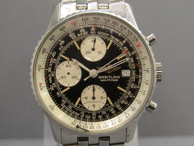 a close up of a watch with a black face