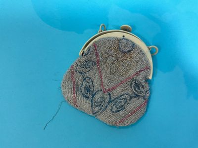 a small purse sitting on top of a blue surface