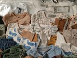 a lot of baby clothes that are in a suitcase