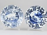 pair of blue and white plates with figures in a landscape
