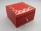 une petite boîte rouge ornée d'un motif doré
