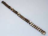 a close up of a metal bracelet on a white surface