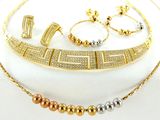 Ensemble composé d'un collier, d'un bracelet et d'une bague en or et en argent, posé sur un fond blanc