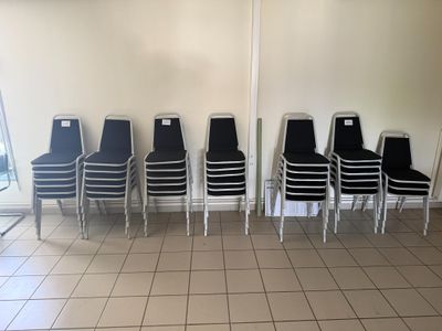 Plusieurs chaises sont alignées contre un mur dans une salle d'attente