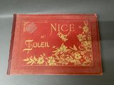 an old red book with gold writing on it sitting on a table