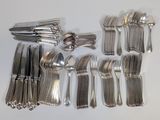 a lot of silver spoons and forks laid out on a table