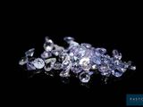 un gros plan sur un tas de diamants posés sur une surface noire