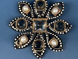 a black and white broochle with pearls and pearls