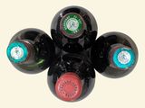 four bottles of wine are arranged in a circle on a white surface