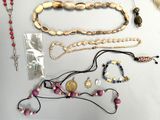 a lot of necklaces and bracelets laid out on a table