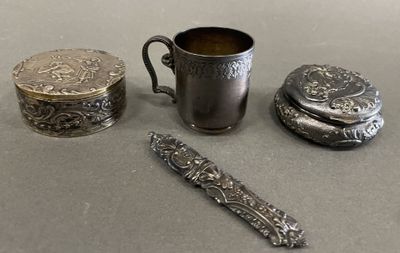 une coupe en argent, une cuillère et d'autres objets en argent posés sur une table