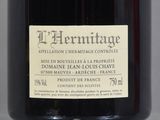 an old bottle of wine sitting on a table with a label on it
