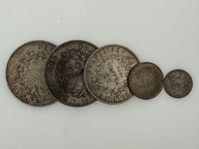several old coins are arranged in a row on a white surface