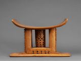 a small wooden stool with a carved design on top of it