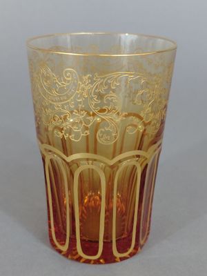 a glass cup with a gold design on it