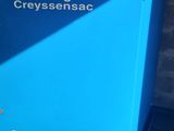 un gros plan d'un séchoir à air bleu posé sur un sol en béton