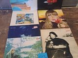 a lot of records sitting on a table in front of a window