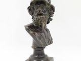 bronze bust of a man with a hat and a beard