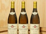 trois bouteilles de vin posées sur un tonneau