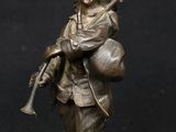 bronze figurine of a woman with a gun and a hat