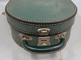a green suitcase sitting on top of a white table