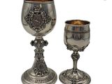 un gobelet en argent et une coupe en argent posés l’un à côté de l’autre