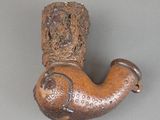 a brown pipe that is sitting on a gray surface