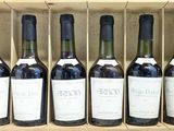 six bouteilles de vin rouge dans un coffret en bois posé sur une étagère