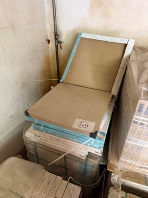 a stack of boxes sitting on the floor next to a toilet