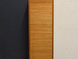 a tall wooden cabinet next to a black wall