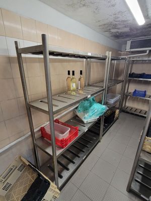 une cuisine avec de nombreuses étagères et des bacs posés par terre