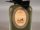 a bottle of perfume with a black bow on it
