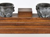 deux vases posés sur un socle en bois, sur fond blanc
