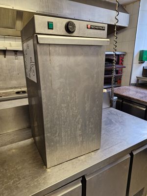 plan de travail en acier inoxydable dans une cuisine professionnelle, avec des fours en arrière-plan