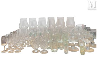 des bouteilles et des verres sont alignés en rang sur une surface blanche
